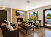 Thumbnail 1 of 12 - A living room with a fireplace and a painting on the wall.
