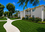 Thumbnail 8 of 12 - A white building with a green lawn in front.