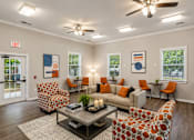Thumbnail 13 of 25 - A living room with orange and white furniture and a ceiling fan.
