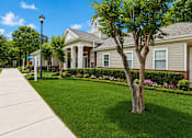Thumbnail 3 of 25 - A tree stands in a grassy area in front of a house.