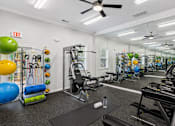 Thumbnail 11 of 25 - A gym with a variety of equipment including treadmills, weights, and exercise balls.