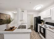 Thumbnail 17 of 25 - A kitchen with black appliances and white cabinets.
