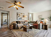 Thumbnail 13 of 21 - A living room with a grey couch and a wooden coffee table.