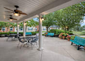 Thumbnail 2 of 20 - A patio with a table and chairs under a roof.