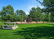 Thumbnail 2 of 15 - A park with a picnic table and playground.
