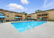 Thumbnail 4 of 23 - A large swimming pool in front of apartment buildings.
