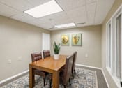 Thumbnail 15 of 16 - A conference room with a table, chairs, and two framed pictures on the wall.