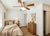 Thumbnail 19 of 22 - A bedroom with a bed, nightstand, and a ceiling fan.