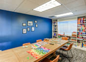 Thumbnail 5 of 26 - Game room with puzzle table and board game storage at The Beckstead Apartments, South Jordan, UT