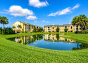 Thumbnail 2 of 24 - A large building is reflected in a pond in front of it.