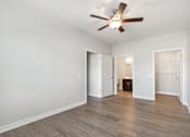 Thumbnail 21 of 36 - A room with a ceiling fan and wooden flooring.