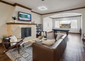Thumbnail 26 of 31 - a living room with a leather couch and a television