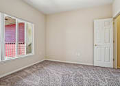 Thumbnail 18 of 36 - A room with a carpeted floor, a white door, and a window with pink blinds.