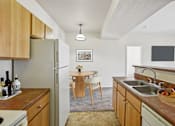 Thumbnail 6 of 36 - A kitchen with wooden cabinets and a refrigerator.