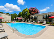 Thumbnail 7 of 16 - A swimming pool surrounded by lounge chairs and umbrellas.