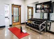 Thumbnail 8 of 16 - A gym room with a television showing a fitness class.