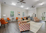 Thumbnail 16 of 20 - A living room with orange chairs and a patterned sofa.