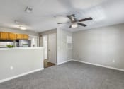 Thumbnail 1 of 29 - an empty living room with a ceiling fan and a kitchen