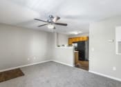 Thumbnail 8 of 29 - an empty living room with a ceiling fan and a kitchen