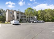 Thumbnail 28 of 29 - an apartment building with cars parked in front of it