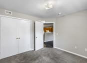 Thumbnail 15 of 29 - a bedroom with white closets and a door to a kitchen