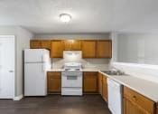 Thumbnail 4 of 29 - the preserve at ballantyne commons apartment kitchen with white appliances and wooden cabinets