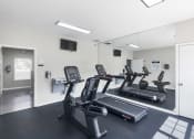 Thumbnail 20 of 29 - a gym with cardio equipment and mirrors in a building