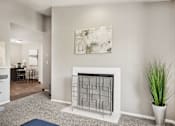 Thumbnail 3 of 24 - A living room with a fireplace and a painting on the wall.