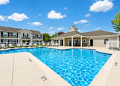 Thumbnail 7 of 37 - A large swimming pool in front of a building with a white fence around it.