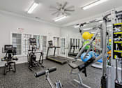 Thumbnail 12 of 20 - A well-equipped gym with various exercise machines and equipment.