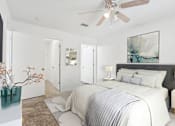 Thumbnail 3 of 20 - A bedroom with a large bed and a ceiling fan.