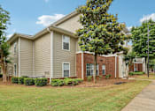 Thumbnail 19 of 20 - A residential building with a beige exterior and a brick section on the side.
