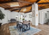 Thumbnail 26 of 35 - a dining room with a wooden ceiling and a table and chairs