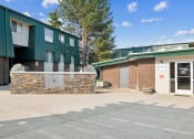 Thumbnail 16 of 35 - a building with a brick and green facade and a parking lot