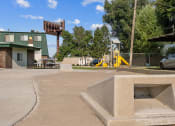 Thumbnail 23 of 35 - a park with a playground and a building in the background