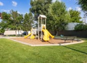 Thumbnail 20 of 35 - a playground with yellow slides and swings in a park