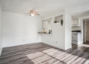 Thumbnail 12 of 35 - an empty living room and kitchen with a ceiling fan