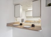 Thumbnail 7 of 35 - a kitchen with white cabinets and a counter with plates and mugs