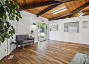 Thumbnail 28 of 35 - a living room with white walls and a wooden ceiling and a sliding glass door