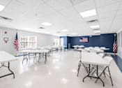 Thumbnail 9 of 17 - A room with tables and chairs and flags on the wall.