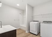 Thumbnail 34 of 36 - A white bathroom with a sink, toilet, and washer.