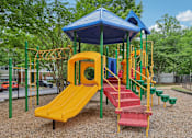 Thumbnail 14 of 20 - A playground with a yellow slide and a blue roof.