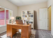 Thumbnail 5 of 36 - A room with a desk, laptop, and bookshelf.