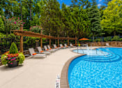 Thumbnail 6 of 15 - A pool surrounded by trees and chairs.