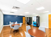 Thumbnail 5 of 17 - A conference room with a table, chairs, and a vending machine.