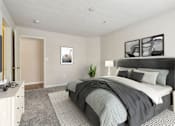 Thumbnail 7 of 17 - A bedroom with a large bed and a nightstand with a lamp.