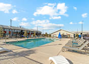 Thumbnail 19 of 36 - A sunny day at the pool with lounge chairs and a clear blue sky.