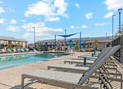 Thumbnail 16 of 36 - A sunny day at the pool with lounge chairs and a play area.