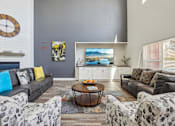 Thumbnail 28 of 36 - A living room with a grey couch and a coffee table.
