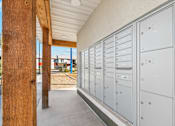 Thumbnail 10 of 36 - A long row of mailboxes are lined up on the side of a building.